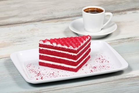 Red velvet cake slice with white frosting